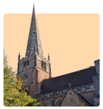 St Alphege Church in Solihull, England, with its tall stone spire and historic architecture, partly framed by trees and set against an orange background.