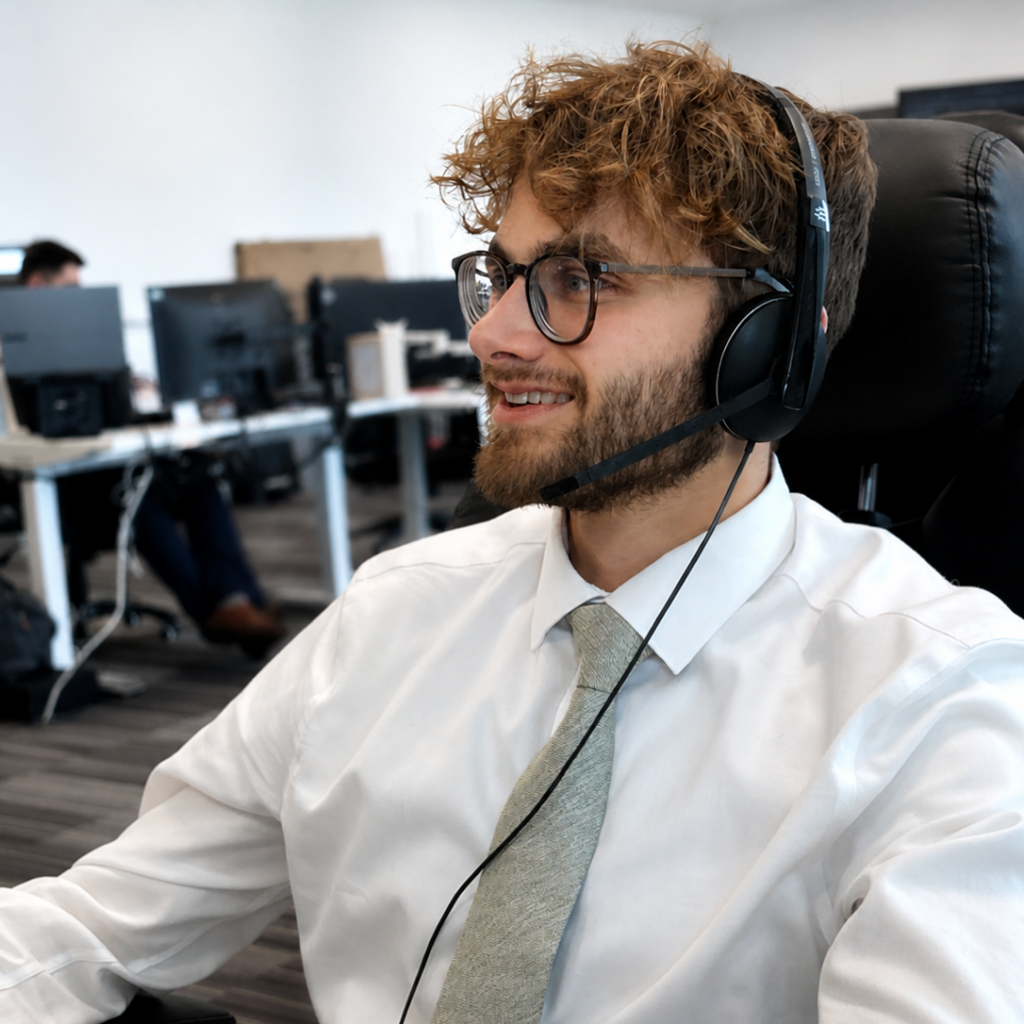 Smiling IT technician wearing a headset in a modern office