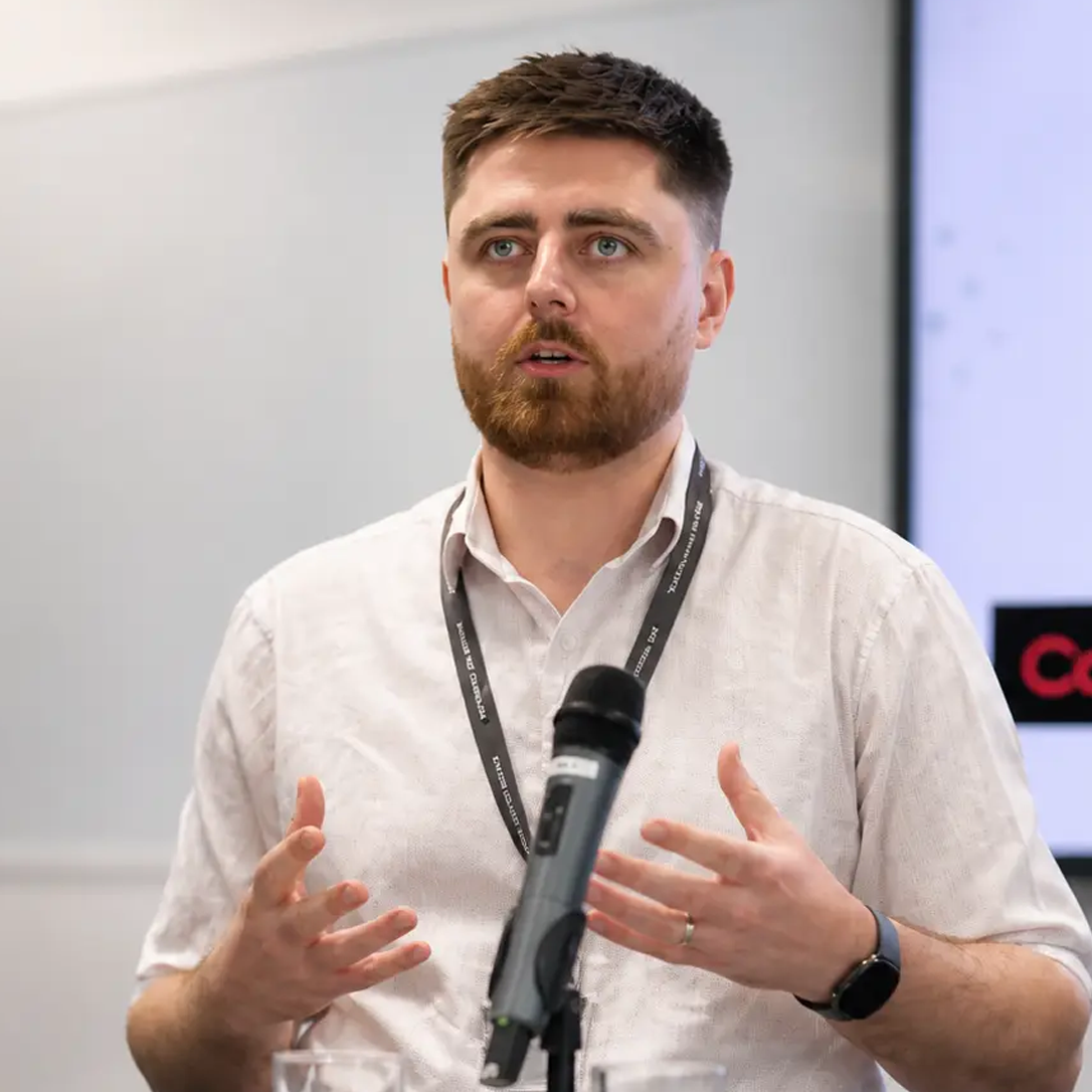Speaker presenting at a conference with a microphone